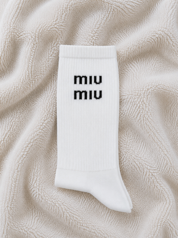 جوراب ساق بلند سفید طرح MIU MIU با نوشته مشکی، فری سایز ۳۶ تا ۴۳ و ترکیب ۸۰ درصد نخ ایرانی.